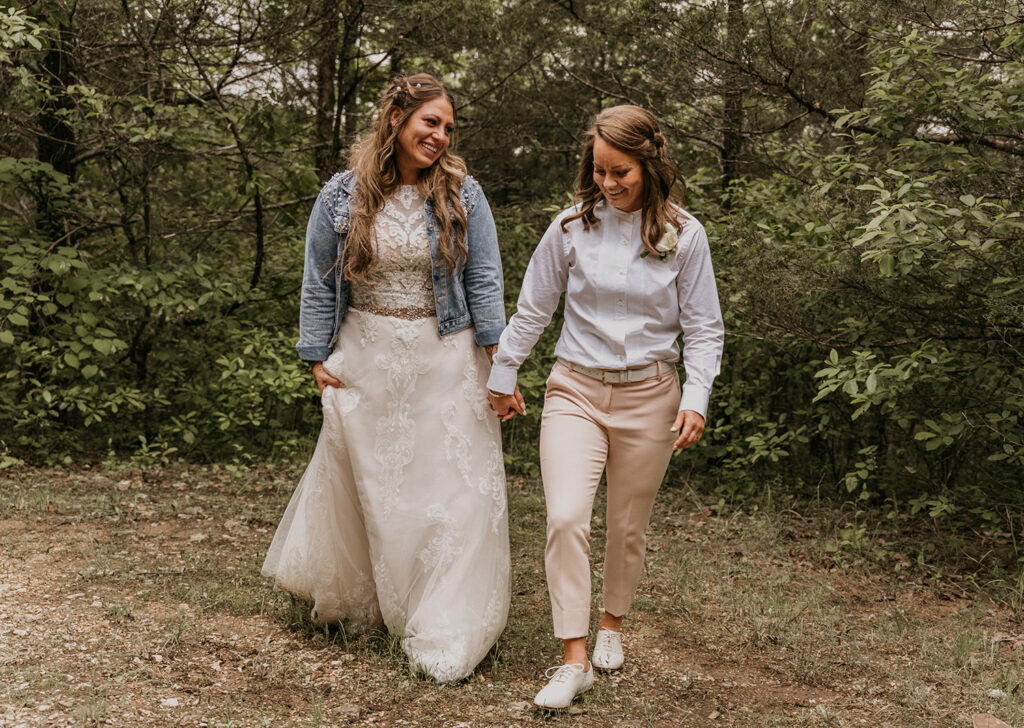 An LGBTQ couple holding hands, smiling and walking during their elopement day in Arkansas.