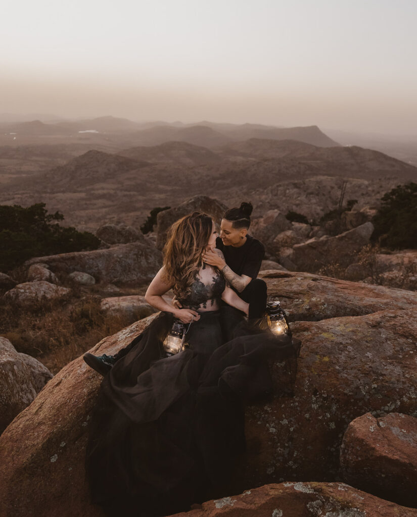 A lesbian sitting on a rock on their elopement day, with views of Oklahoma's mountains behind them.