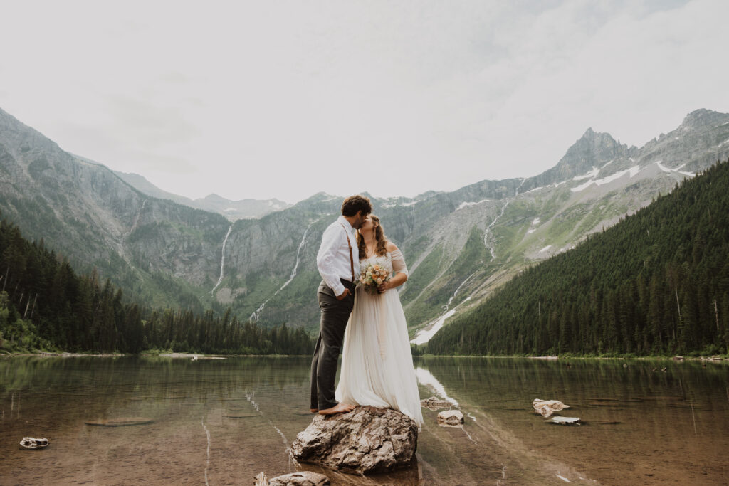 A couple kiss on their wedding day in glacier national park