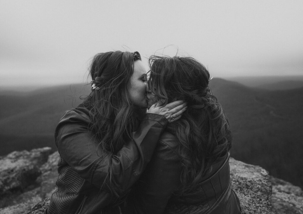 A black and white image of a lgbtq couple kissing in the mountains of arkansas.