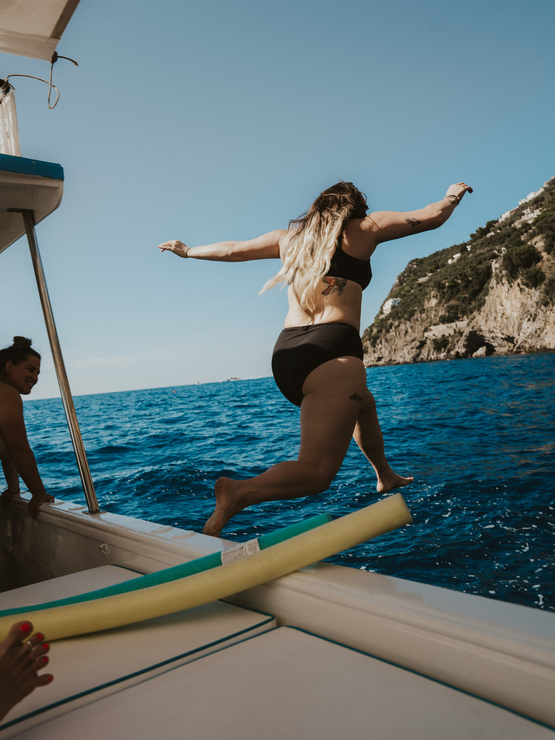 Jumping from private boat in Positano, Italy for boat tour. 